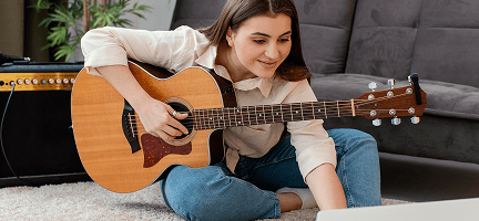 Alumna tocando la guitarra en casa